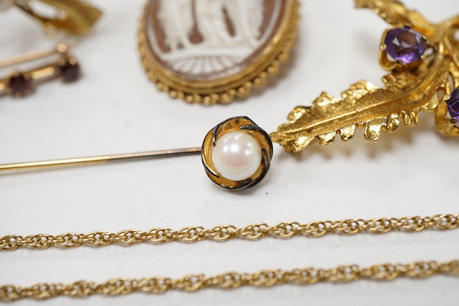 A collection 9ct brooches to include a shell cameo carved with the Three Graces, an amethyst set floral spray brooch, a cultured pearl set ribbon brooch, a garnet set bar brooch and a cultured pearl set stick pin, togeth